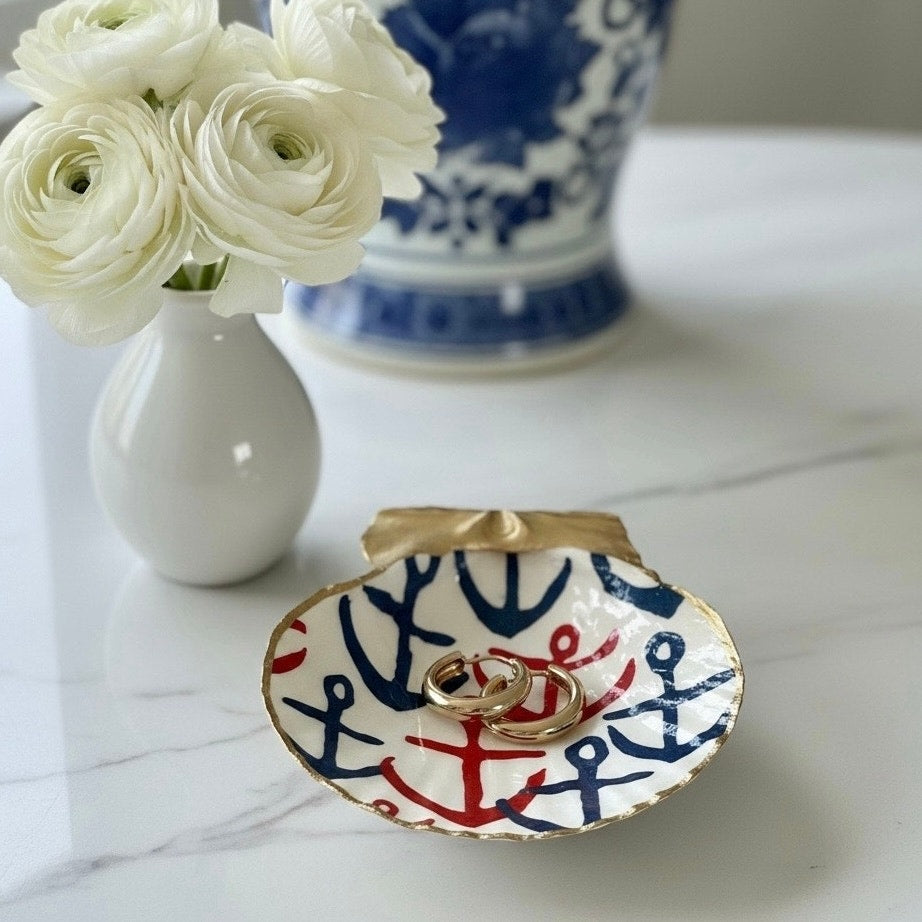 Anchor scallop shell jewelry dish holding gold hoop earrings