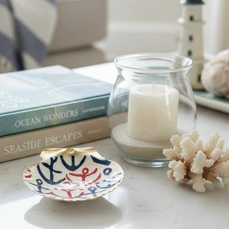 Nautical anchor shell trinket dish styled with coastal books, candle and coral